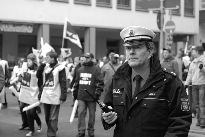 a group of men in uniform stand on the street, while someone holds his cell phone