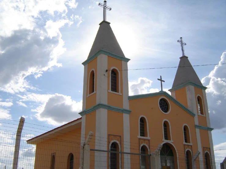 a church in rural area with fence and light tower