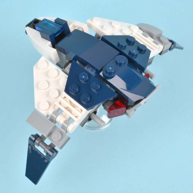 a large lego spaceship in action on a blue background