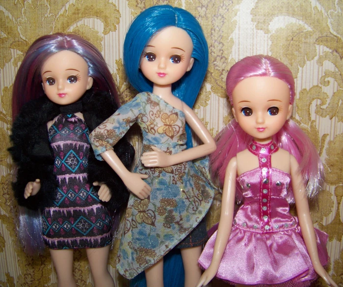 a group of three dolls standing next to each other