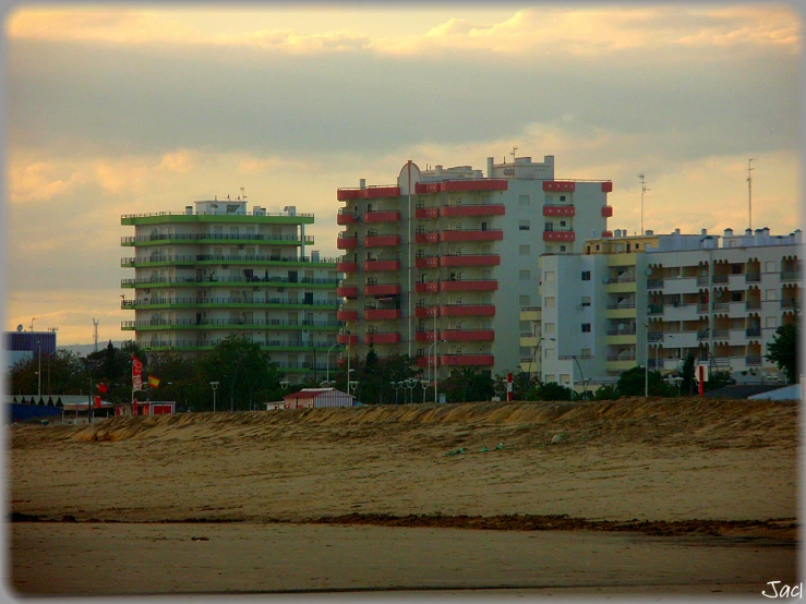 a large building on a beach with cars and trucks in the background