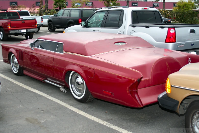 a red car is sitting in a parking lot