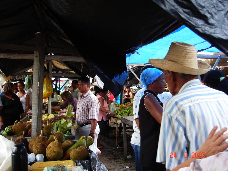 people looking at fruits in an open market