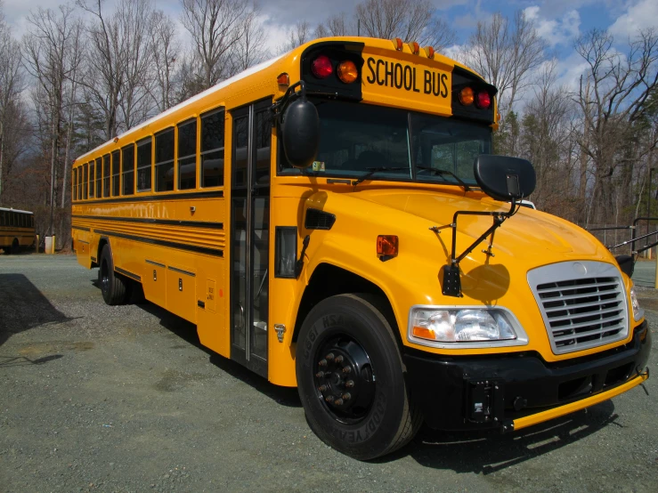 a school bus parked in a parking lot with the light on