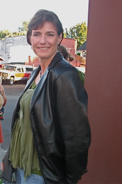 an older woman is smiling with a small owl on her shoulder