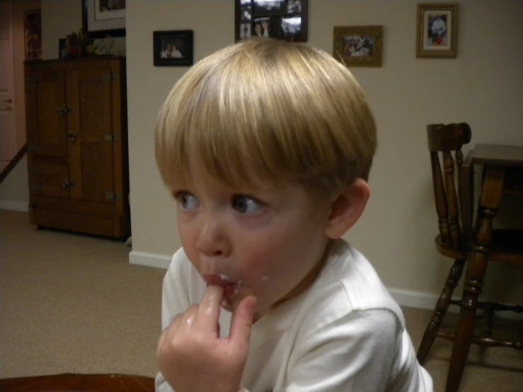 a small boy eating food off of a plastic fork