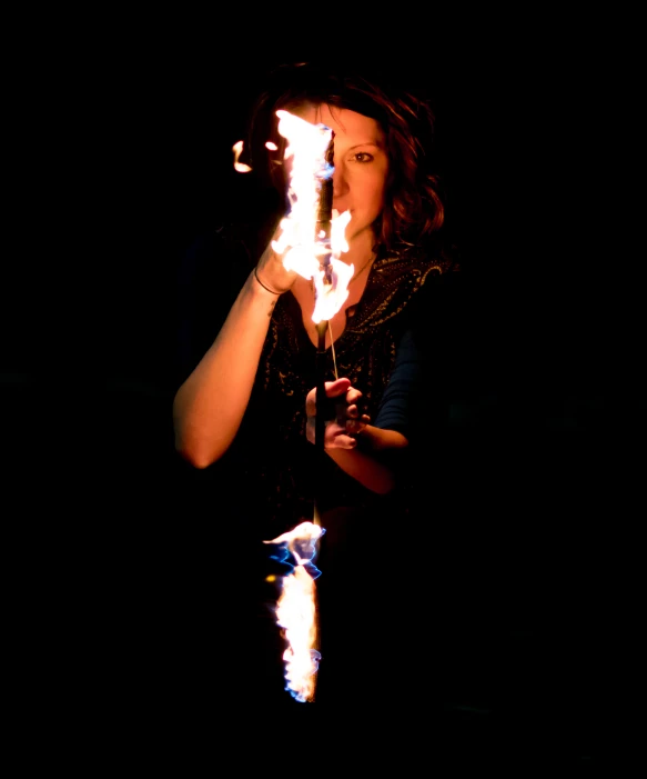 a woman with a stick of fire in her hand