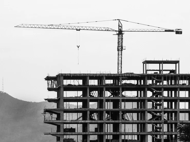 construction cranes sit atop the top of a building