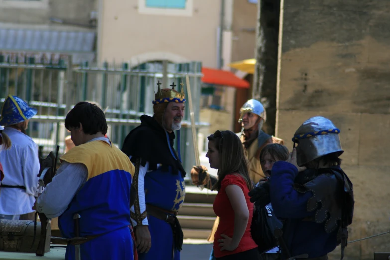 a man with a beard and a crown talking to children