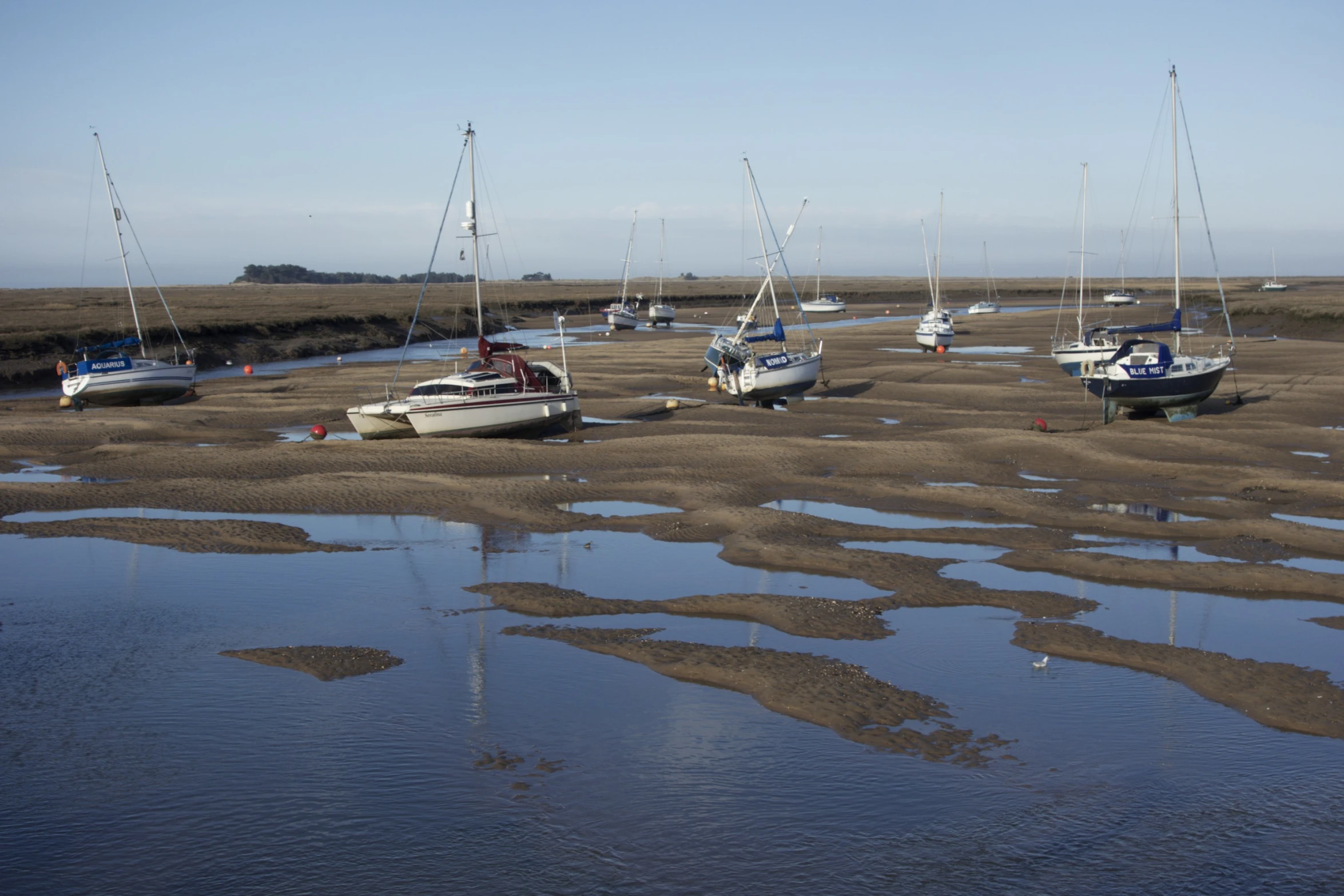 the small boats are parked at low tide