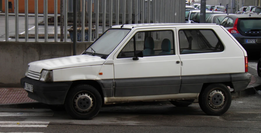 a white van sitting in a parking lot next to a fence