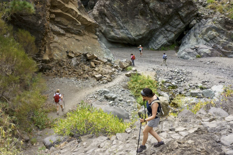 several people hiking up and down rocky mountain