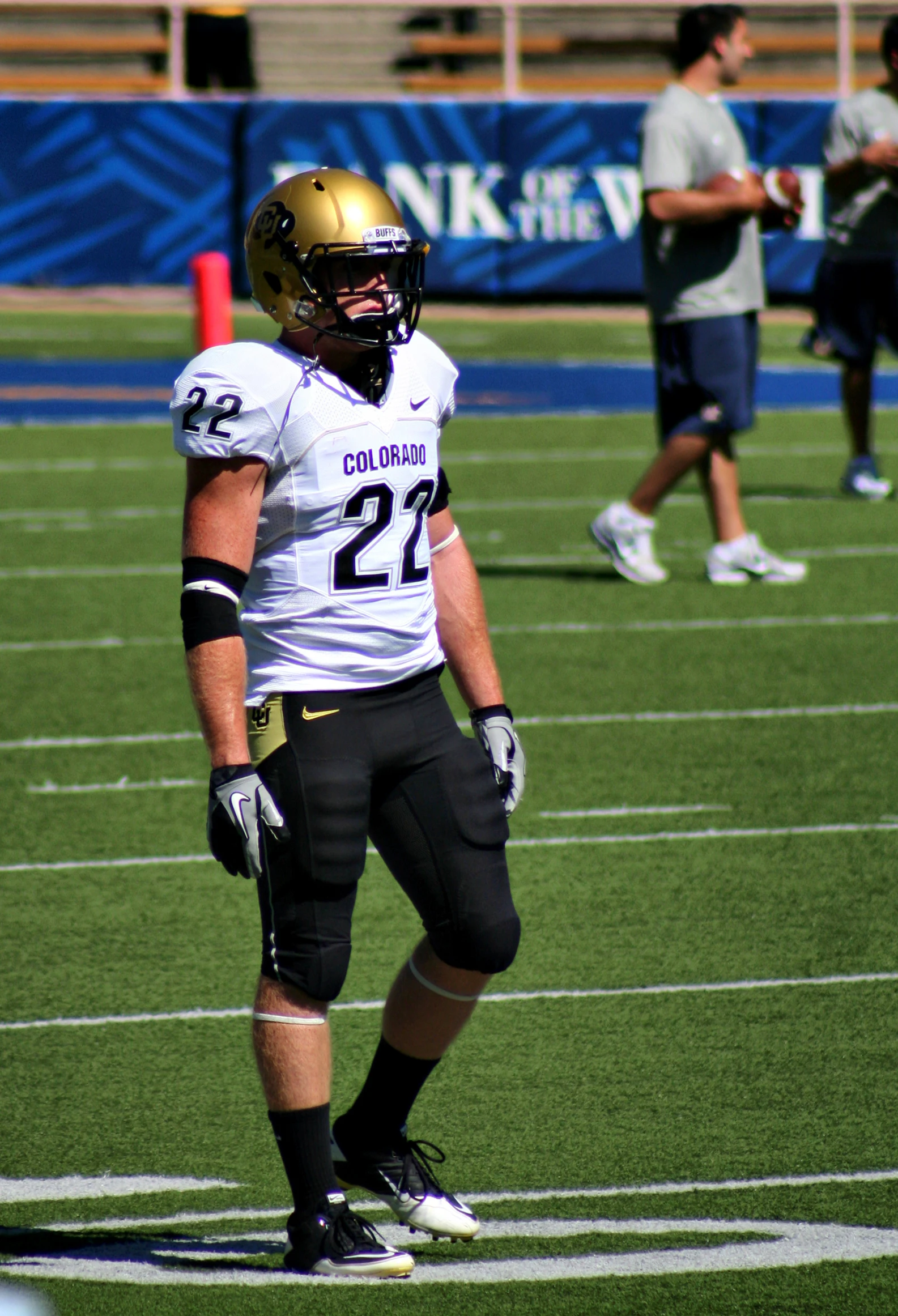 a football player holding onto his helmet in the game