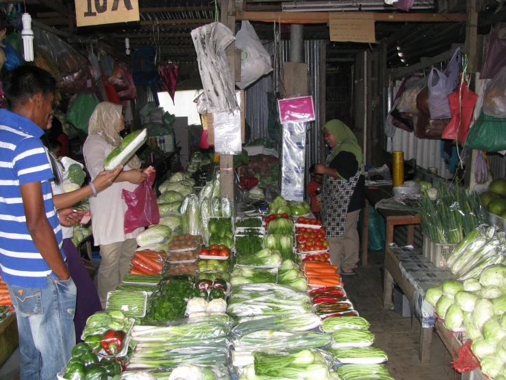 people are shopping in an outdoor market