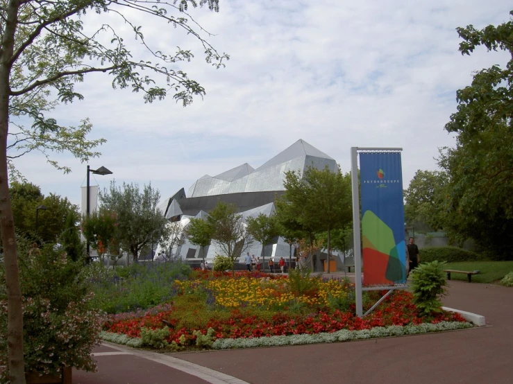 large colorful sign and trees near walkway in front of building