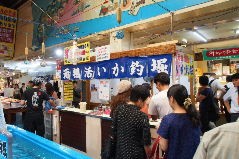 a group of people standing in line waiting at a food counter