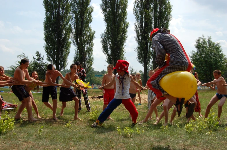 a man in striped shirt dancing in a field with other people