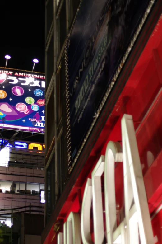 a neon light display in the night with buildings