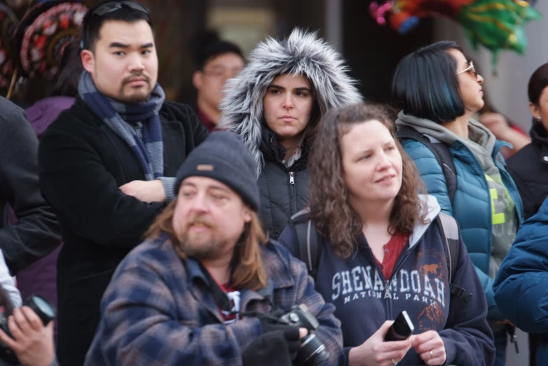 group of people are looking over their shoulders and listening to soing