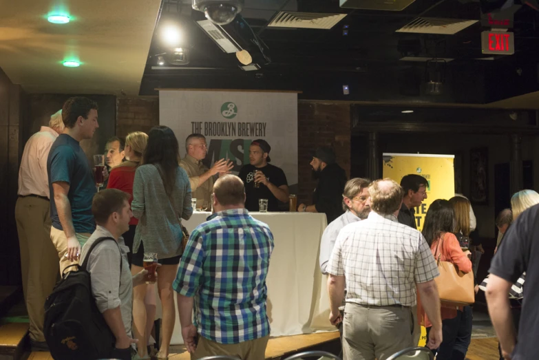 a group of people standing around tables and chairs