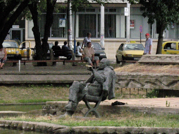 statues of people standing in front of a small fountain