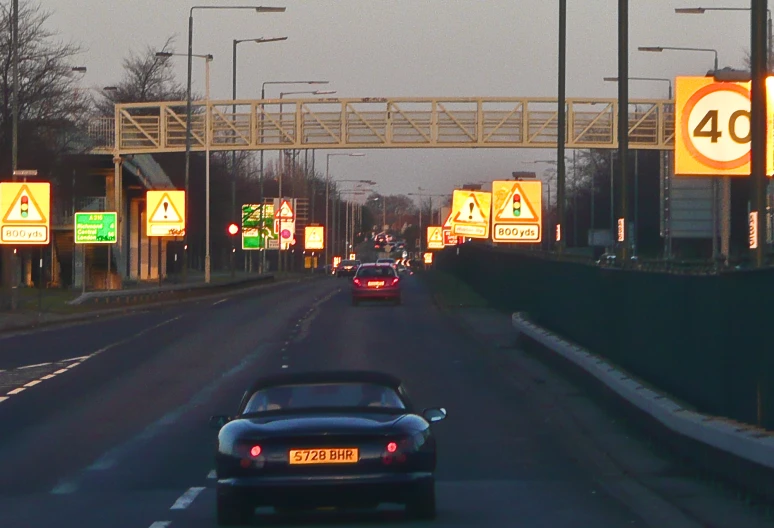 a car driving down an empty street, with lights on all sides