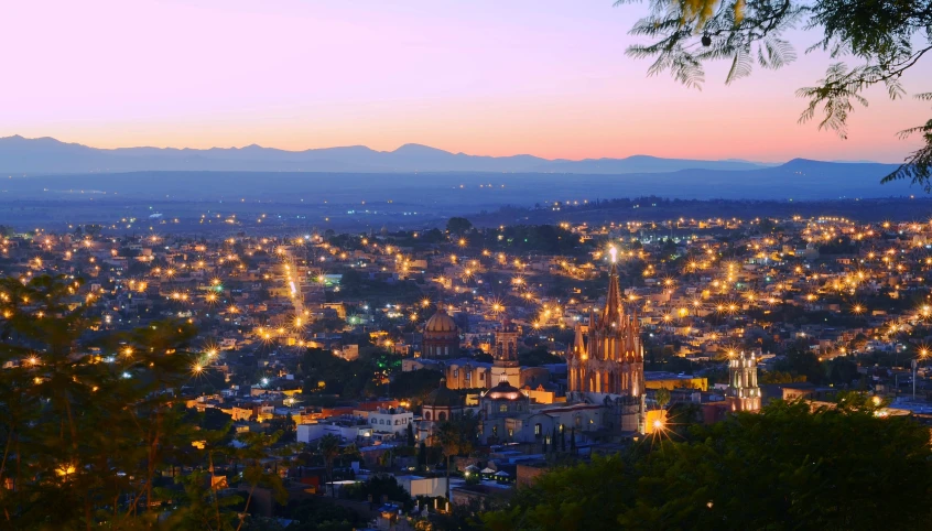 a view of the city at night from an incline