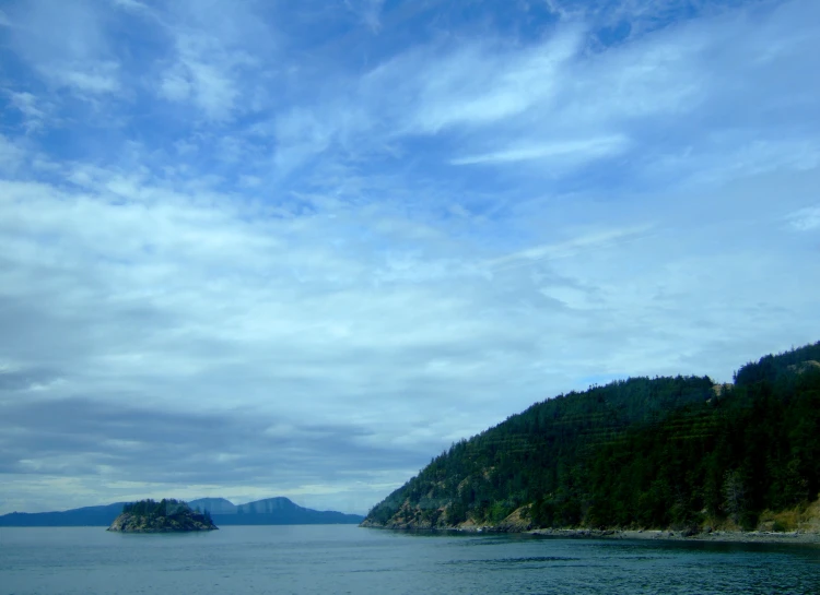 some mountains near water and blue sky