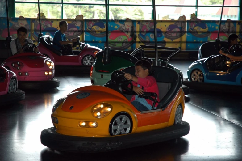 two children on bumper cars ride in an indoor space