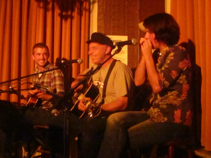 a man and a woman sitting next to each other while they are singing