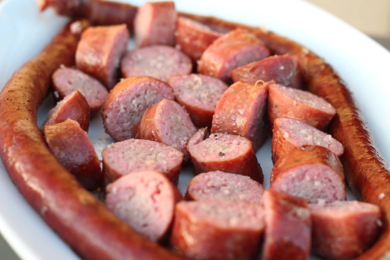 sausages are cooked in a white baking dish