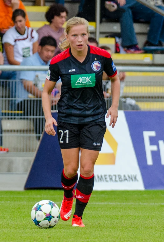 woman playing soccer during the day while a crowd watches