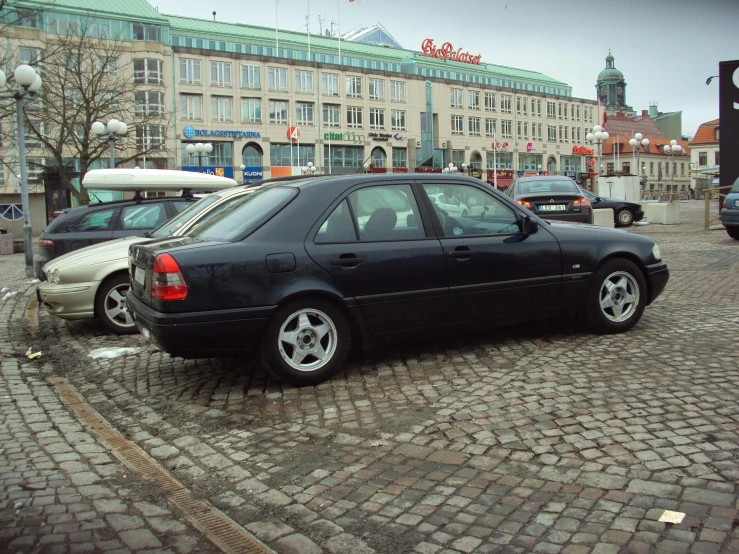 a car parked in a stone street next to some buildings