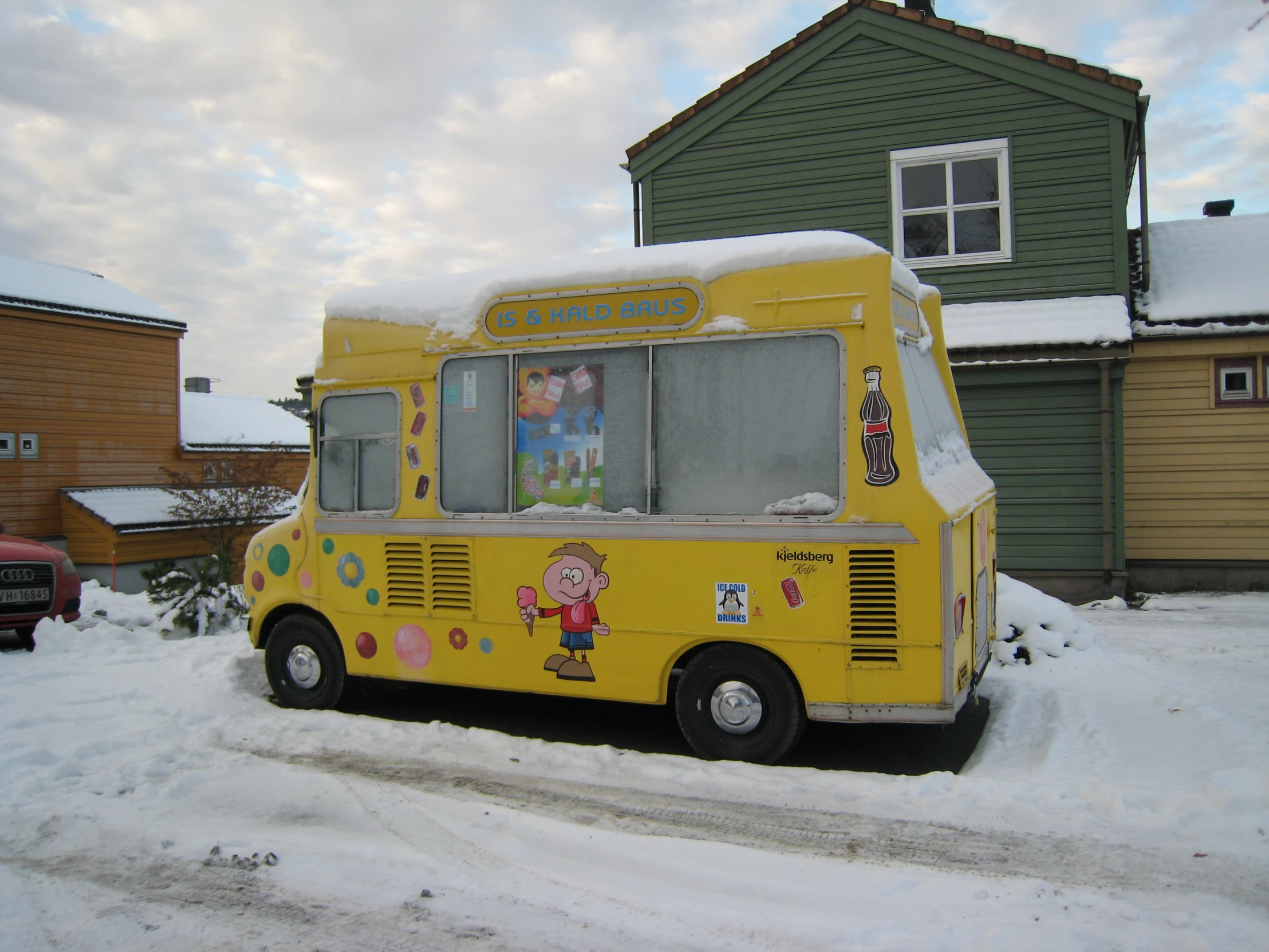 the yellow food truck is parked on the snowy road