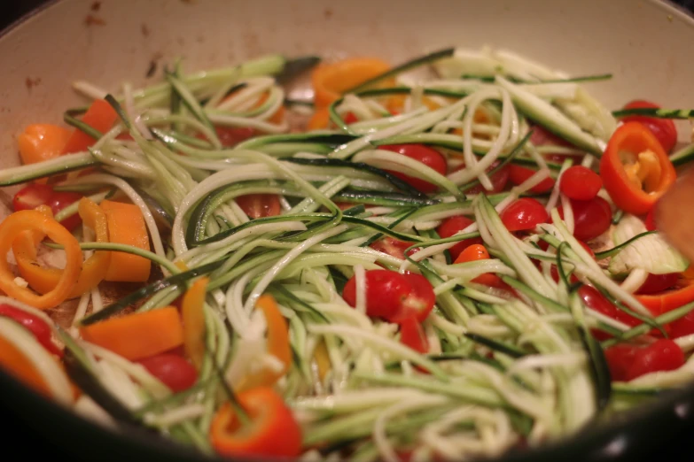 stir fried veggies with onions and tomatoes being prepared