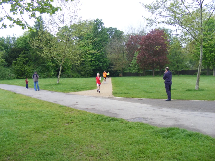 some boys are standing near a ramp and another boy is standing on a path