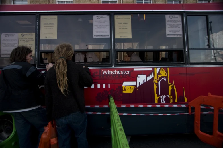 two people waiting to board a bus