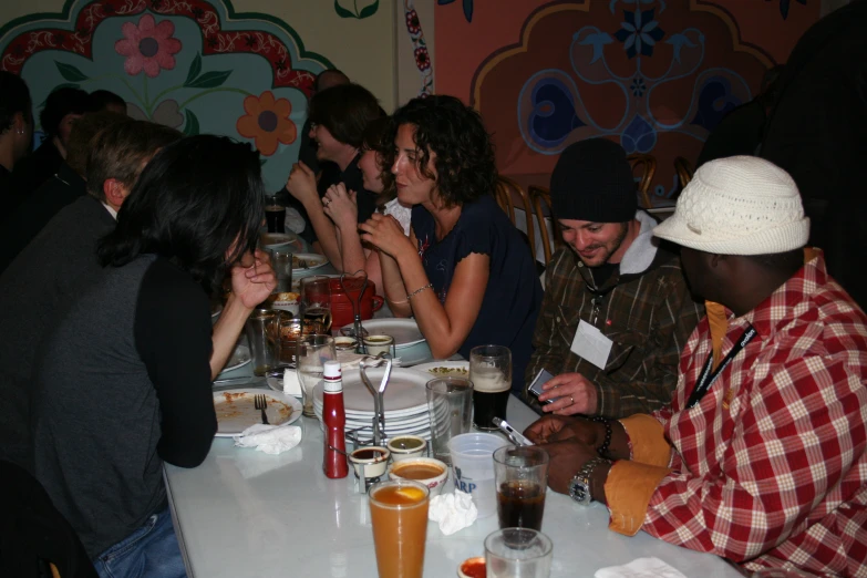 people sitting at a table with drinks and food