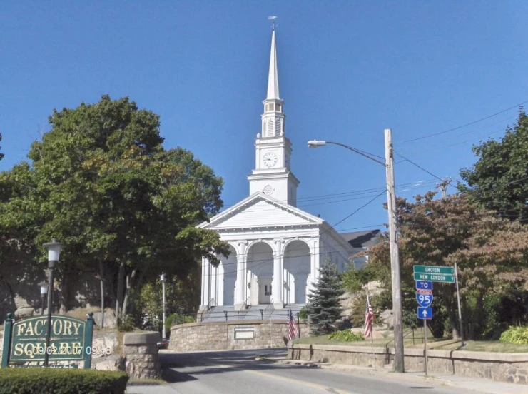 a small white church stands on a quiet city street