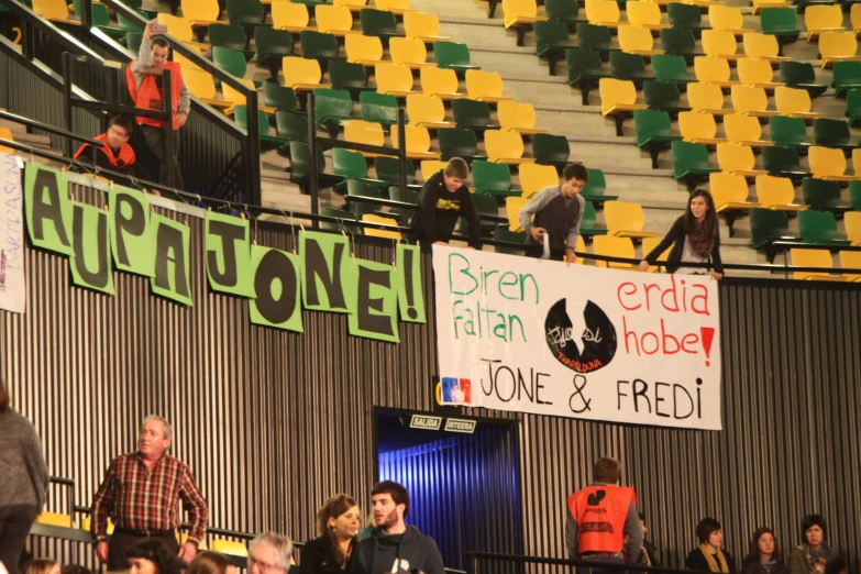 a group of people in the stands looking over a banner