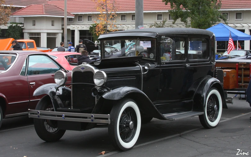 an antique car sits in the middle of a parking lot