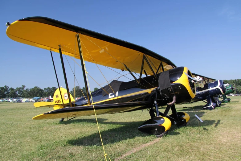 a small yellow airplane parked on top of a field