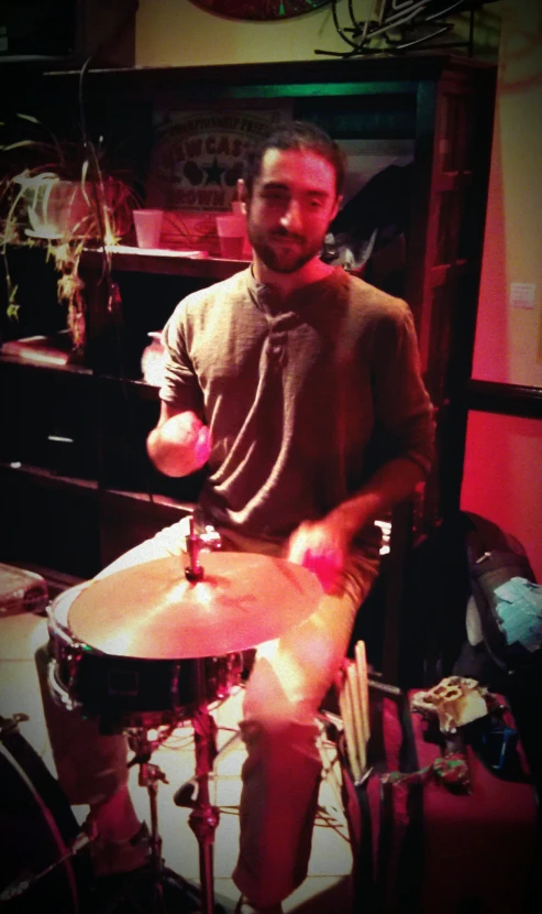 a man that is playing drums in front of a set of sound equipment