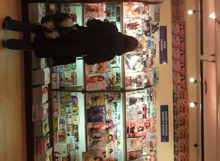 a woman stands in front of a display of comic books