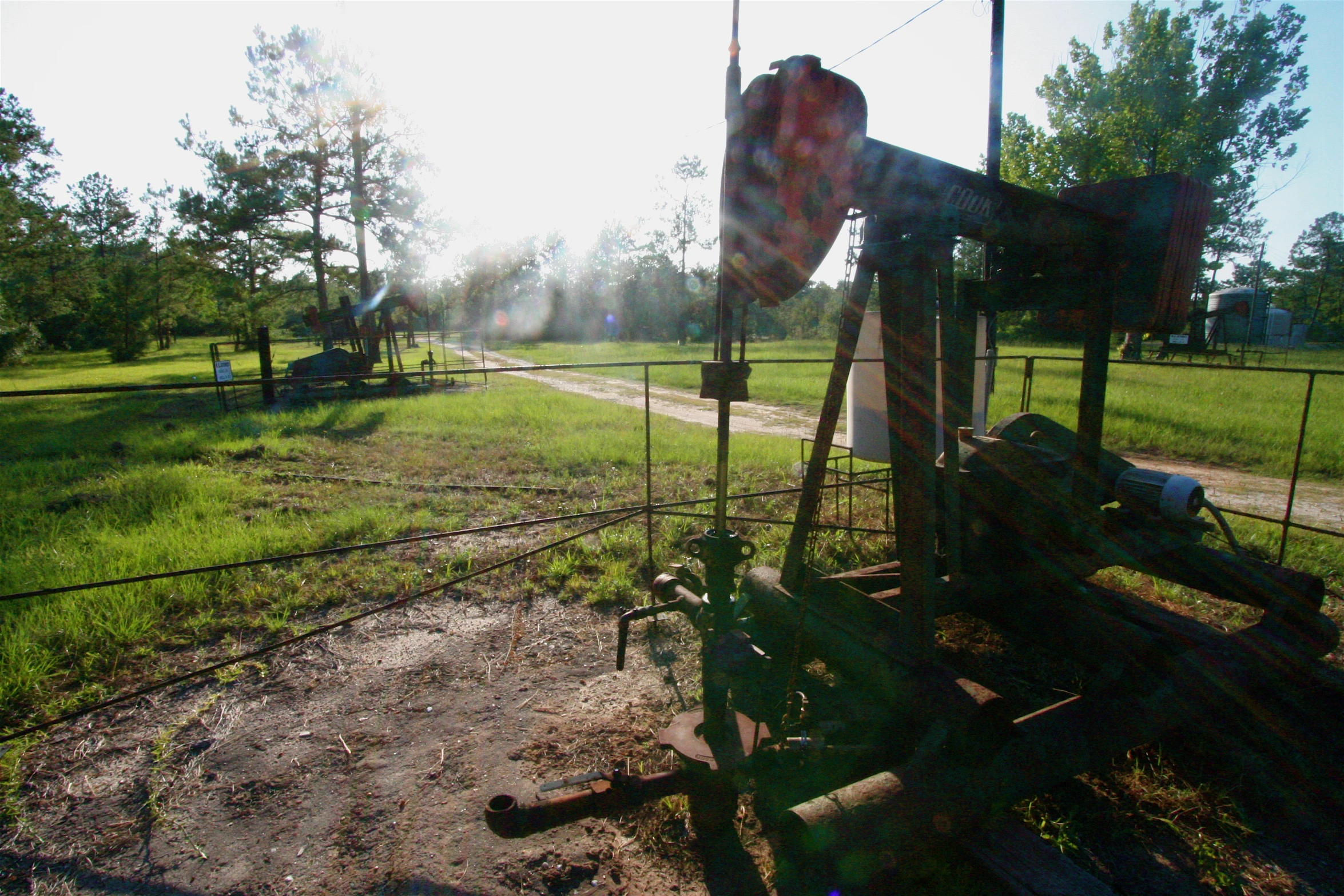 an old broken down gas pump near a field