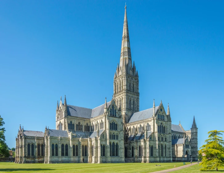 large cathedral with pointed spire stands under a clear blue sky