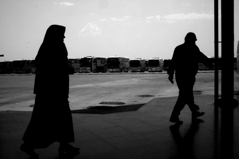 two people are walking by a plane at the airport