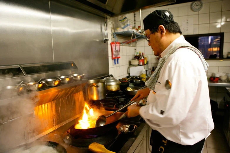 a chef cooking over the stove with his hand