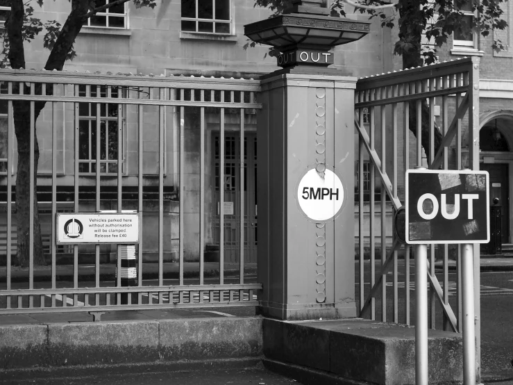 a couple of black and white signs on a metal fence