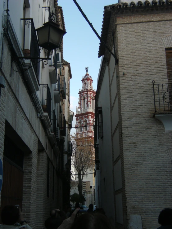 an old street is filled with buildings and a church tower